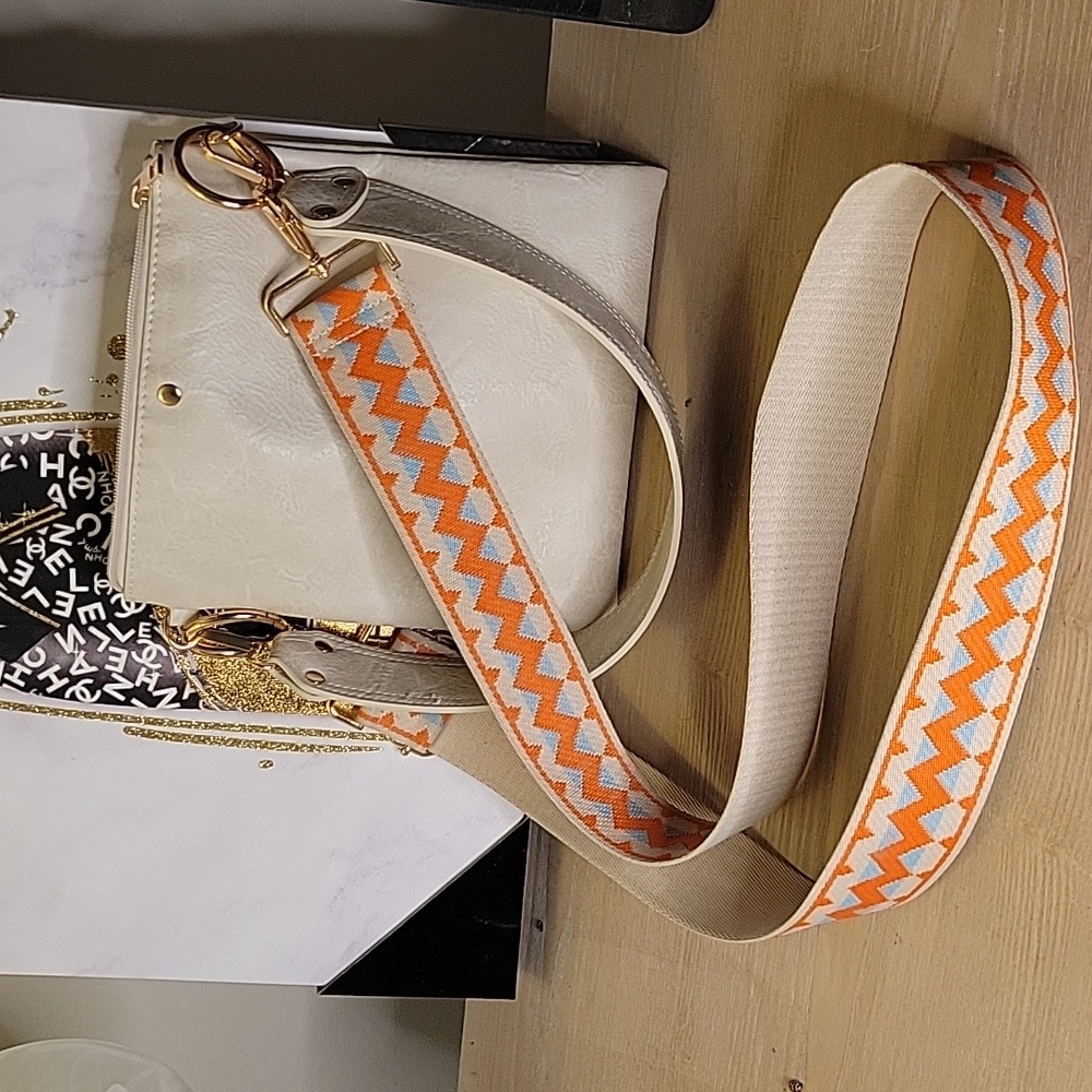 Ah- dorned cream faux leather bag with guitar strap